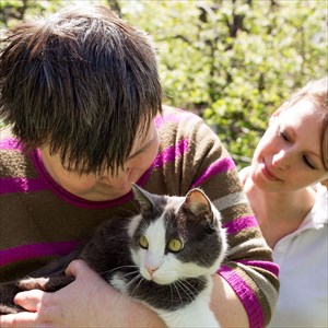 Disabled woman interacting with a cat (and animal handler)