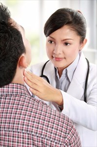 Doctor performing a physical exam on a young man with enlarged lymph nodes.