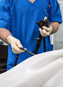 Doctor holding endoscope ready for procedure in theatre.