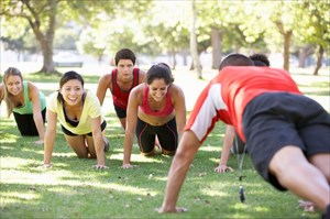 Group of friends exercising together outdoors.
