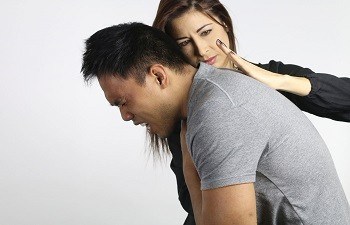 Young woman assisting a man experiencing a choking incident