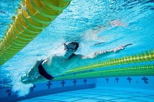 Young man doing freestyle swimming in the pool.