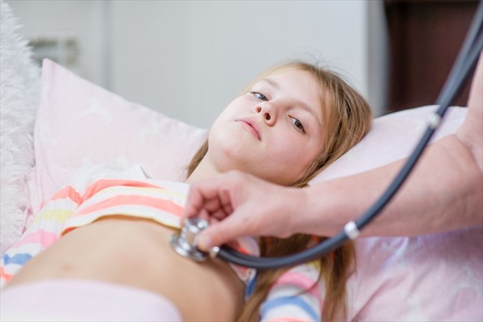Close up of medical doctor doctor examining a teenage girl with stethoscope.