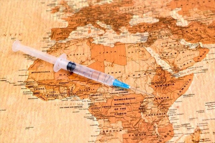 Close-up of a syringe on a map of Africa.
