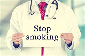 Doctor holding up a 'stop smoking ' sign 