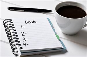 Notebook with a blank list of goals and a cup of coffee