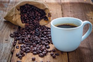 Coffee cup and coffee beans on old wood