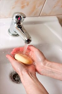 Hands washing with soap in the bathroom sink