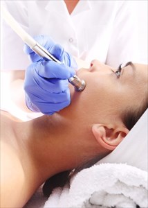 Relaxed woman during a microdermabrasion treatment in beauty salon.