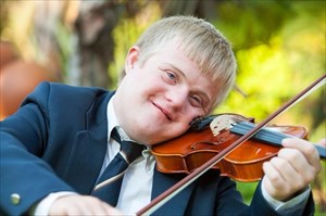 Young boy with down syndrome practicing the violin.